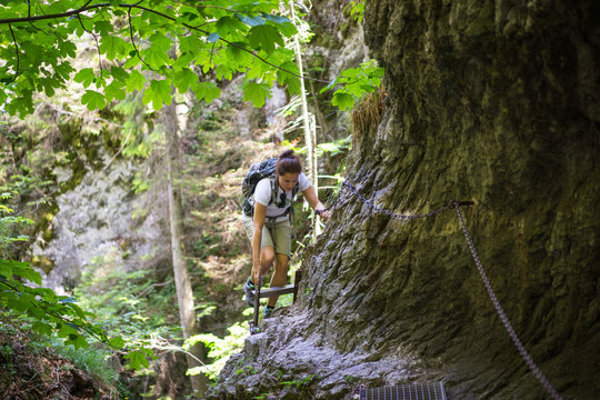 Young woman on a difficult trail in Slovak Paradise National Park. Horizontal view of challenging trail in a Slovak Paradise NP.