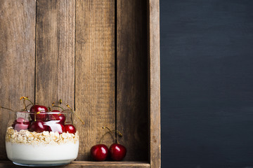 Homemade breakfast with white plain yogurt and cherries on the wooden background