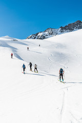 Fototapeta na wymiar Skiers ascending a mountain slope.