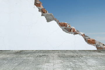 Old wooden floor with cracked bricks wall and blue sky