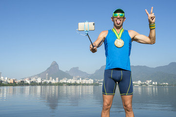 Gold medal athlete celebrating in a photo with his mobile phone on a selfie stick at Lagoa Rodrigo de Freitas Lagoon in Rio de Janeiro, Brazil