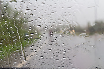Road view through car windshield with rain drops, Driving in rain.