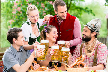 Obraz premium Freunde im Biergarten in Bayern trinken im Sommer