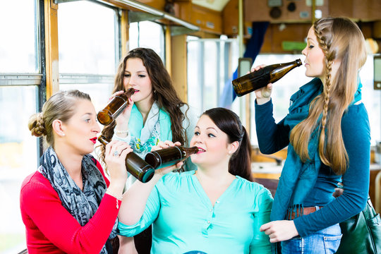 Gruppe Leute in Stra&szlig;enbahn Bar feiern mit Bier