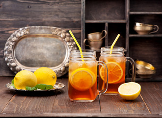 Iced tea with lemon on a rustic wooden background