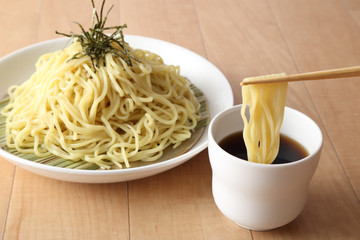 ざるラーメンを箸ですくう