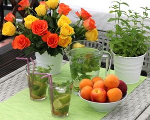 Refreshing summer relaxation: mojito cocktail, fruits and roses