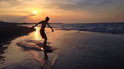 boy on surf at sunset