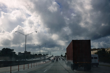 Fototapeta na wymiar Miami Florida rainy driving road with trucks