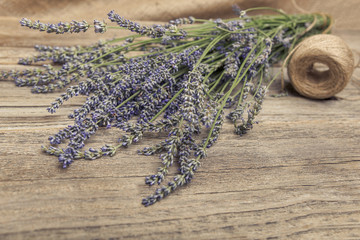 Bouquet of lavender and thread on a wooden table.