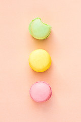 multicolored macaroon on beige paper background, flat lay, top view