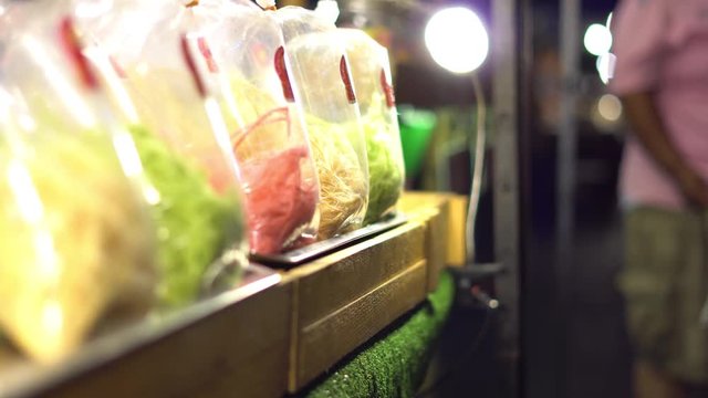 Asian night market. Chief cooking exotic sweets like candy and chewing gum. 4K