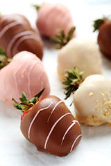 Strawberries covered in chocolate on a white pergament