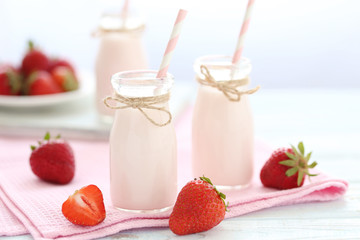Strawberry yogurt in bottle on wooden table