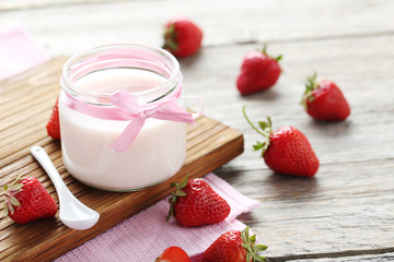 Strawberry yogurt in glass on wooden table
