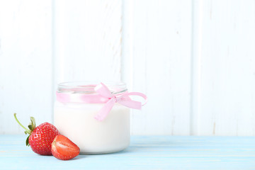 Strawberry yogurt in glass on wooden table