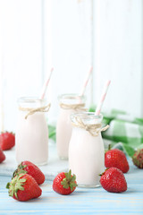 Strawberry yogurt in bottle on wooden table