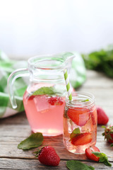 Fototapeta na wymiar Fresh strawberry drink in bottle on wooden table