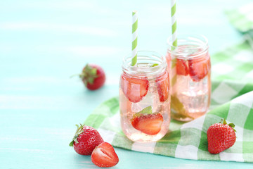 Fresh strawberry drink in bottle on wooden table
