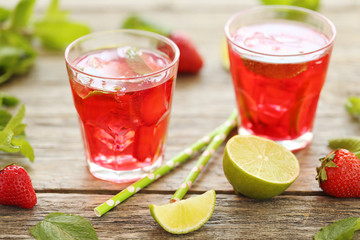 Fresh strawberry drink in glass with lime on wooden table