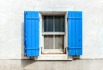 window with blue shutters on white wall background