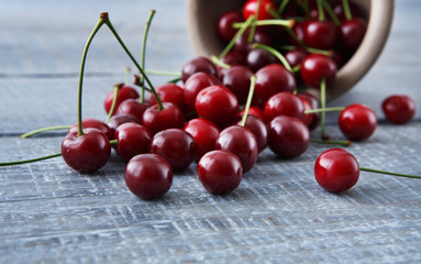 Fresh cherries closeup with green leaves on blue rustic wood