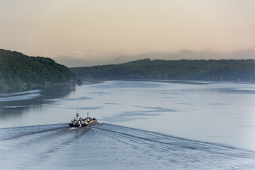 Dawn on the Hudson River: Sunrise beginning on the Hudson River near Poughkeepsie as a cargo ship makes its way northward towards Albany, NY