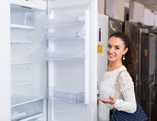 Fototapeta na wymiar brunette choosing new refrigerator