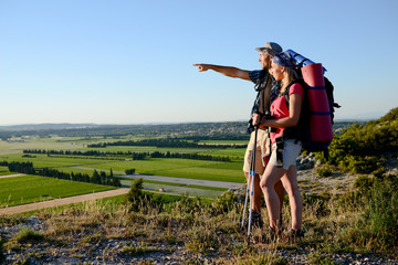 young couple hiking on an adventure trek and looking at beautiful landscape