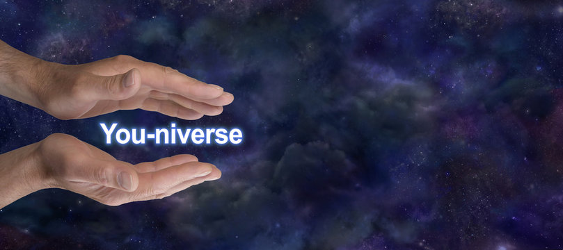 You are connected to ALL THAT IS - a pair of male parallel hands with You-niverse floating between on a dark starry night sky background with copy space 