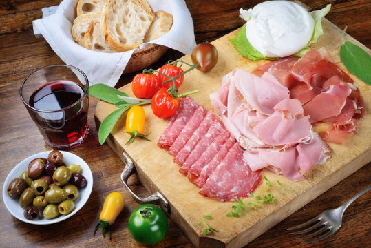 Cold cuts: ham, roast ham, salami with buffalo mozzarella, olives and red wine Chianti
