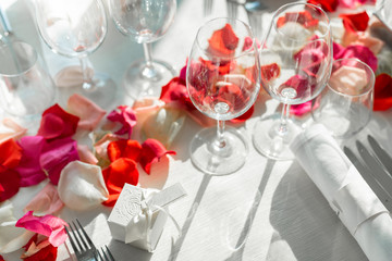 Bright wedding event table decoration with rose petals at a restaurant