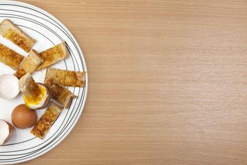 Egg and toasted soldiers on a white pattened plate