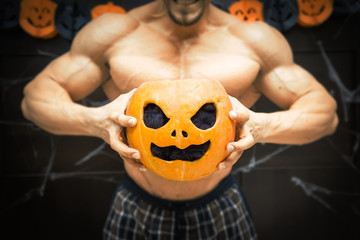 Halloween bodybuilder with pumpkin