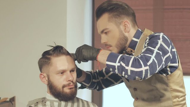 men's hairstyling and haircutting with hair clipper in a barber shop or hair salon