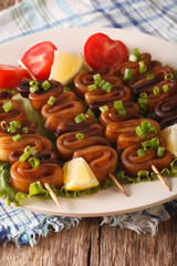 Squid rings on skewers with lemon macro. Vertical
