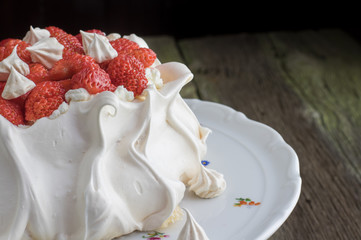 Detail on a Strawberries Pavlova Cake on a White Dessert Plate