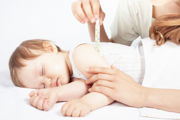 Child has a high temperature or fever, using a thermometer © petunyia