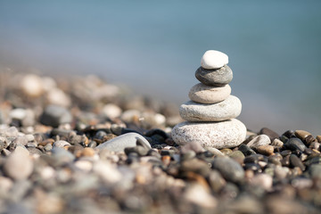 Fototapeta na wymiar pile of white stones on the beach. Sea blurred background