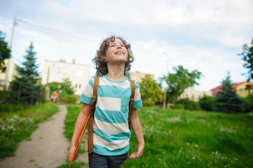 The schoolboy comes back from school in good mood.