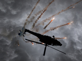 Silhouette of an attack helicopter firing flares
