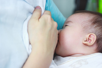 Closeup portrait of mother breastfeeding her newborn baby 