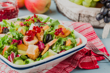 Fresh French salad with baked camembert, cranberries and fresh f