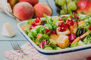 Fresh French salad with baked camembert, cranberries and fresh f