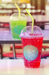 Soft drink in  plastic cups on the table,red warm color.