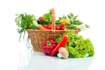 Composition with raw vegetables in wicker basket isolated on whi