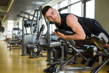 Fototapeta na wymiar man does sports exercises in the gym