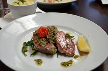 detail photography of tuna fish with capari and lemon in restaurant