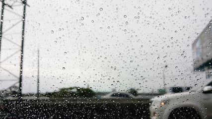 Raindrops on car's window with highway view