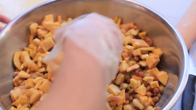 Chef mixing fruits in a bowl.
